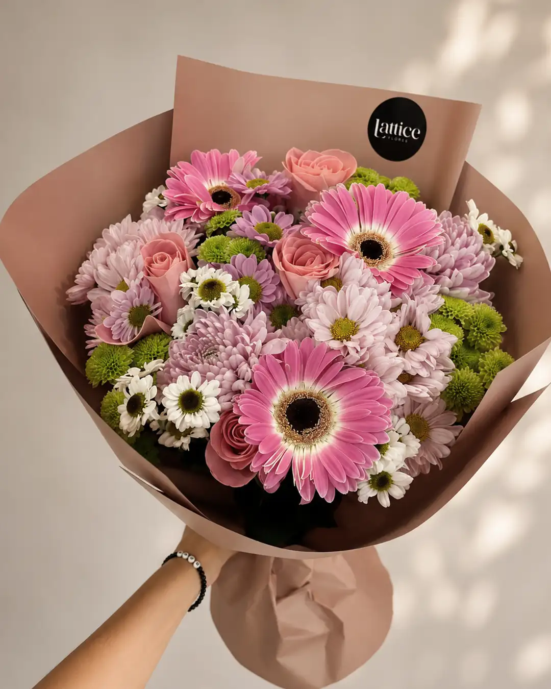 Una encantadora mezcla de gerberas, rosas, crisantemos y margaritas en delicados tonos rosados que transmite alegría, dulzura y frescura.